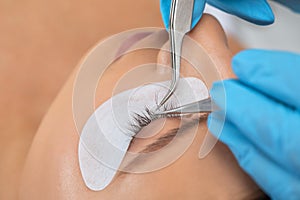 Beautiful Woman with long eyelashes in a beauty salon. Eyelash extension procedure. Lashes close up