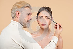 Beautiful woman with long eyelashes, eyebrows. Makeup and cosmetology concept. Professional man visagiste make up artist