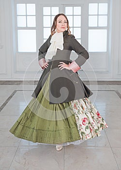 Beautiful woman in long green medieval dress and frock-coat dancing