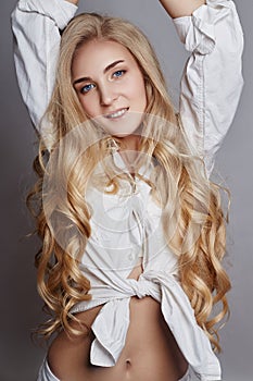 Beautiful woman long hair coloring in ultra blond, natural make-up. Stylish hairstyle curls done in a beauty salon. Fashion blonde