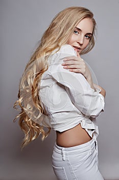 Beautiful woman long hair coloring in ultra blond, natural make-up. Stylish hairstyle curls done in a beauty salon. Fashion blonde