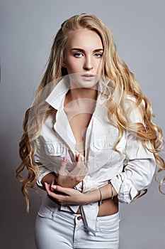 Beautiful woman long hair coloring in ultra blond, natural make-up. Stylish hairstyle curls done in a beauty salon. Fashion blonde