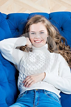 beautiful woman with long hair lies on sofa