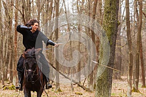 Beautiful woman with long hair shot an arrow from her bow