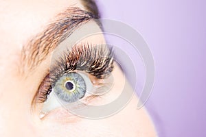 Beautiful Woman with long lashes in a beauty salon. Eyelash extension.