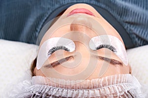 Beautiful Woman with long lashes in a beauty salon. Eyelash extension procedure