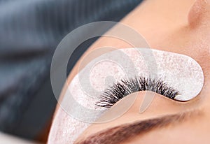 Beautiful Woman with long lashes in a beauty salon. Eyelash extension procedure