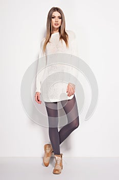 Beautiful woman with long legs dressed elegant posing in the studio