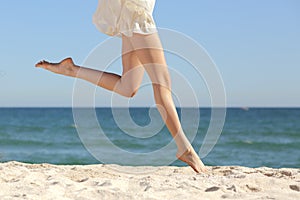 Beautiful woman long legs jumping on the beach photo