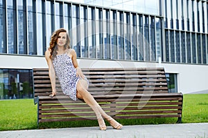 Beautiful woman with long legs sitting on bench