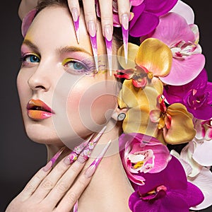 Beautiful woman with long nails, perfect skin, hair of orchids.