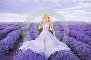 Beautiful woman in a long purple dress on a background of lavender . A girl in the form of a fairy and a nymph of flowers