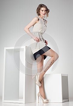 Beautiful woman with long legs dressed elegant posing in the studio - full body