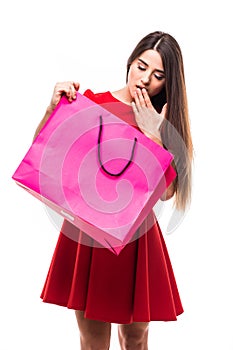 Beautiful woman look at color shoping bag with happy shocked face on white background