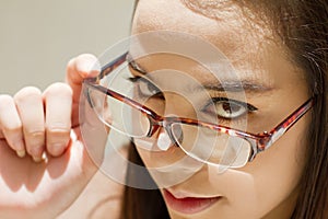 Beautiful woman look through her eyeglasses, concept of finding