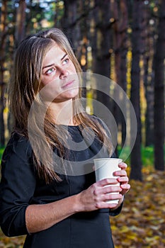 Beautiful woman looking at camera holding a cup of coffee
