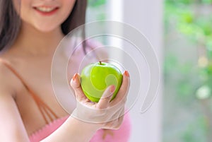 Beautiful woman looking at green apple with happy face for healthy and beauty lifestyle