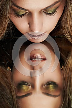 Beautiful woman looking her reflection in a mirror