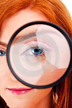 Beautiful woman looking through a magnifying glass