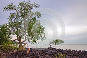 Beautiful woman looking at the scenic view on rocky seashore