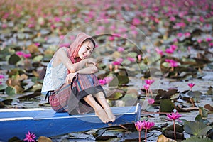 Beautiful woman with lotus flower at the red lotus sea