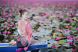 Beautiful woman with lotus flower at the red lotus sea