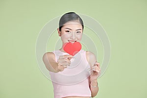 Beautiful woman in love and holding heart shape, exhilarated woman holding a valentine greeting card in hands