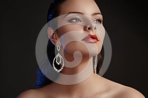 Beautiful woman in luxury fashion earrings. Diamond shiny jewelry with brilliants. Accessories jewelery, fashion makeup