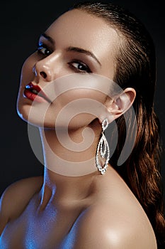 Beautiful woman in luxury fashion earrings. Diamond shiny jewelry with brilliants. Accessories jewelery, fashion makeup