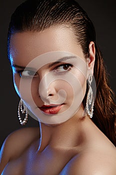 Beautiful woman in luxury fashion earrings. Diamond shiny jewelry with brilliants. Accessories jewelery, fashion makeup