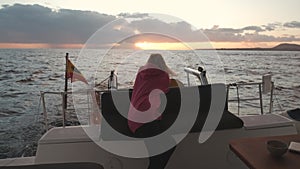 Beautiful woman on a luxury yacht enjoying the best sunset or sunrise in the ocean during a cruise. Go everywhere