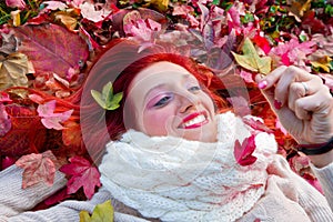 Beautiful woman lying on autumn leaves