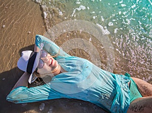 Beautiful woman lying on the beach sunbathing by the sea