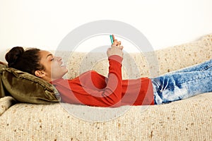 Beautiful woman lying on couch with smart phone