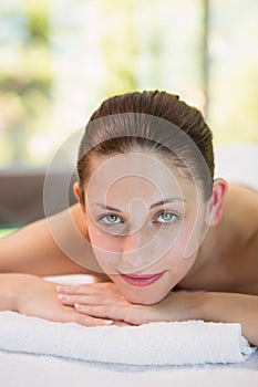 Beautiful woman lying on massage table at spa center