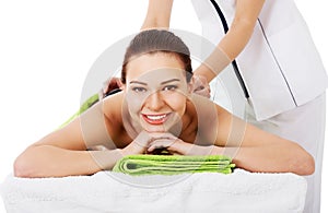 Beautiful woman lying on spa salon having stone massage.