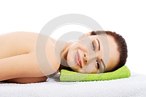 Beautiful woman lying at spa salon.