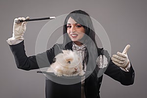 Beautiful woman magician with rabbit in hat