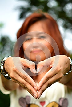 Beautiful woman make heart shape with hand