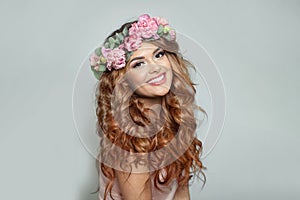 Beautiful woman with make-up, perfect white smile and summer season rose flower wreath on her long healthy shiny hair