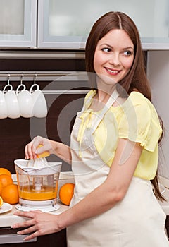 Beautiful woman making orange juice