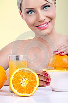 Beautiful woman making orange juice