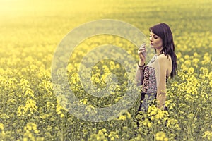 Mujer hermosa en prado de flores feliz olfateando 