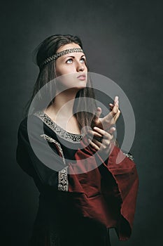 Beautiful woman in medieval dress praying