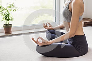 Beautiful woman meditate at home. Young girl practicing yoga indoors. Harmony, balance, meditation, relaxation at home concept