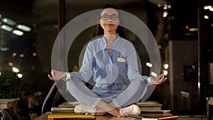 Beautiful woman meditating on office desk, break time to boost productivity