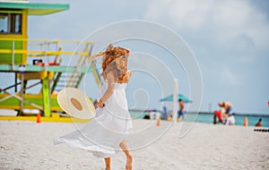 Beautiful woman on the miami beach. Girl walking barefoot on white sand of tropical island.