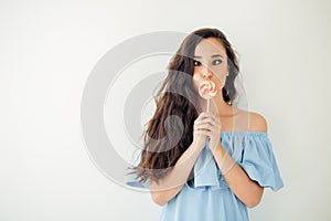Beautiful woman model with pink lips and lollipop on white background
