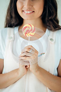 Beautiful woman model with pink lips and lollipop on white background