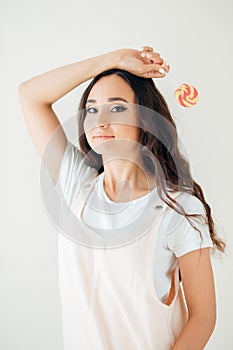 Beautiful woman model with pink lips and lollipop on white background